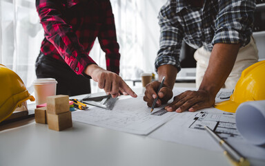 Engineers work as a team with blueprints for architectural plans. Engineer sketching construction project concept with architect equipment Architects talking at table Teamwork and construction concept