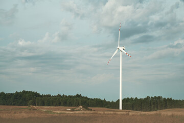 Beautiful sunset above the windmills on the field. Sustainable future and renewable energy