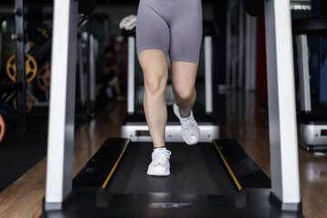 Attractive young sports woman working out in gym, cardio training on treadmill running on treadmill