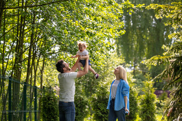 Fototapeta premium Happy young dad playing with his son and looking contented