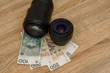 Używany sprzęt fotograficzny obiektywy i pieniądze na biurku 