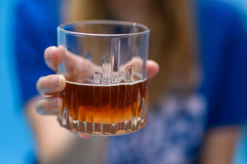 Kobieta trzymająca w dłoni szklankę z whisky