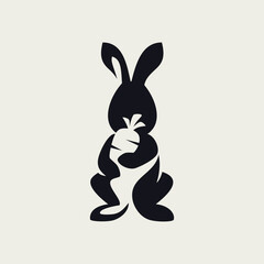 Simple Cartoon Silhouette Bunny Black Rabbit Stand looking front with Hand Holding a Carrot to the Chest Negative Space Vector Logo Design
