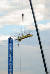 disassembly of construction cranes using a lifting arm, worker on top of Metal struture
