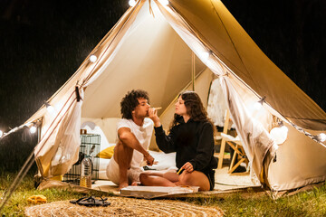 couple in love eating pizza in a camping tent