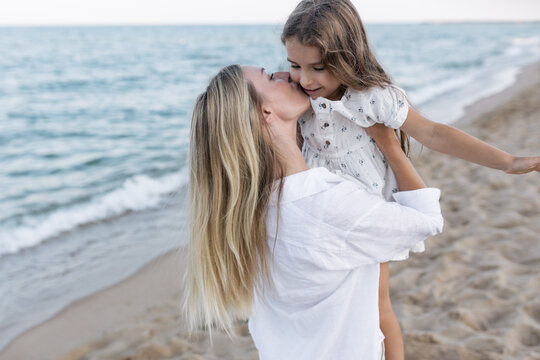 Mother's love for daughter. Mother and daughter play near the sea