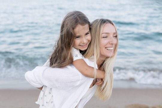 Mother's love for daughter. Mother and daughter play near the sea