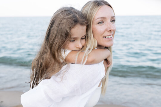 Mother's love for daughter. Mother and daughter play near the sea