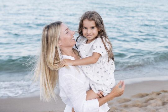 Mother's love for daughter. Mother and daughter play near the sea