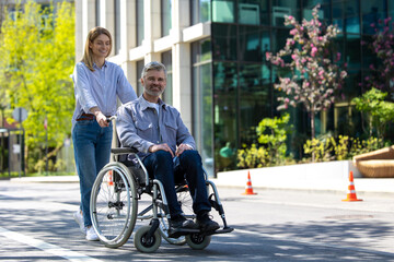 Obraz premium Husband in wheelchair and loving wife walking in city street.