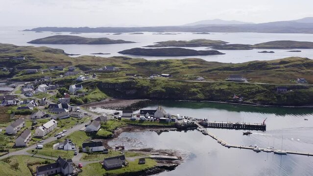 Aerial shot circling the village on the Isle of Scalpay, an island near the Isles of Harris and Lewis on the Outer Hebrides of Scotland. The Minch sea is visible in the background.