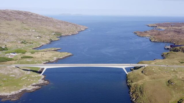 Drone shot circling the bridge connecting the Isle of Scalpay to the Isle of Harris on the Outer Hebrides of Scotland. The town of Tarbert and the surrounding bay is visible.