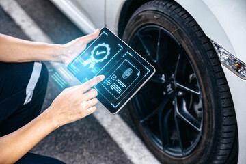 Mechanic technician holding tablet and checking to car tire in auto repair shop garage, Wheel tire...