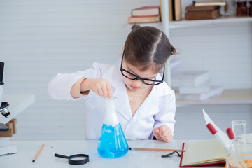 Curiosity modern Arabian girl primary school student wearing lab coats happy studying chemical substance analyzing test in laboratory room, lifestyle learning education science class for little kids