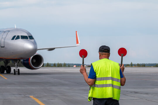 Airplane marshalling at the airport apron. Passenger aircraft meeting