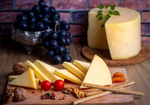 Kashar cheese or kashkaval cheese on wood floor. Cheese slices on the serving board