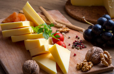 Kashar cheese or kashkaval cheese on wood floor. Cheese slices on the serving board (Turkish name; Kars Kasari)