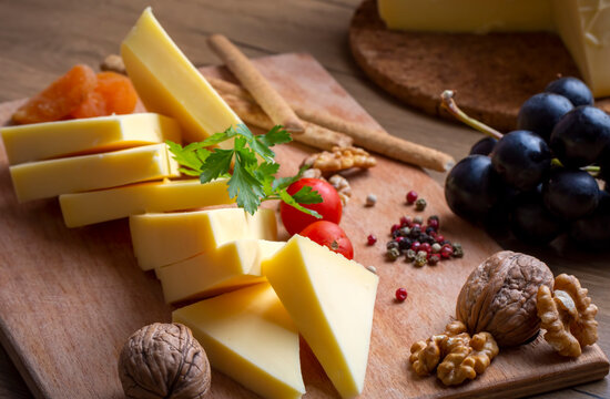 Kashar cheese or kashkaval cheese on wood floor. Cheese slices on the serving board (Turkish name; Kars Kasari)