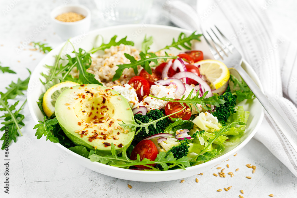 Sticker oatmeal porridge with avocado, cottage cheese, tomatoes, fresh green salad and arugula. healthy brea