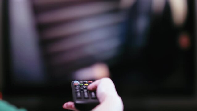 Interactive TV Experience: Close-Up Hand Operating Remote Control and Changing Channels on Television