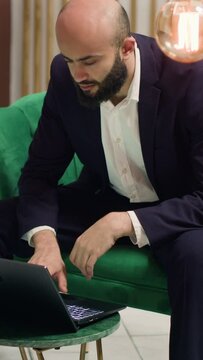 Vertical Video Entrepreneur working on project ideas while he waits in lounge area, business trip. Manager sent to negociate with collaborators to ensure partnership for company growth on global stage