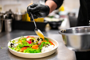 chef hands cooking Fresh sashimi salad with salmon fish, tuna and vegetables on kitchen