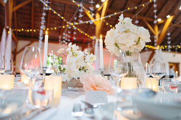 Beautiful table setting and decorations at a wedding. Wedding venue with beautiful decor, flowers,...
