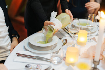 Green soup on a white plate at wedding