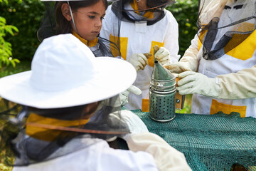 Girls learning about apiculture while examining smoker