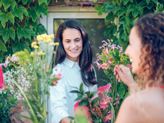 Smiling female florist and client in flower shop