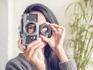 Anonymous woman with vintage photo camera and lens