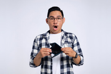 No money. Shocked young Asian man in casual shirt showing empty wallet, having financial problems isolated on white background
