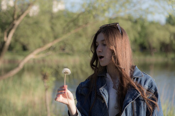 Portrait of a beautiful girl with a dandelion.