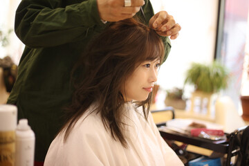 美容室でヘアセットをする女性