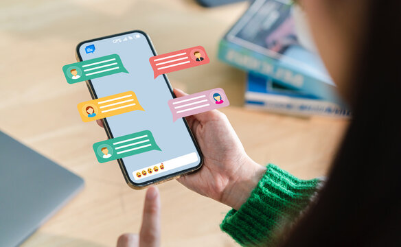 Human hand using smartphone typing Live chat chatting and social network concepts, chatting conversation working at home in chat box icons pop up. Social media marketing technology concept.