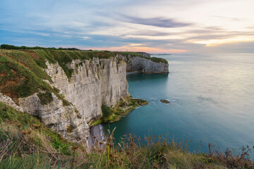 Fototapeta na wymiar Sunrise view of the cliff of Etretat, Normandy, France. Coastal landscape of white rocks and la Manche channel. Popular travel destination