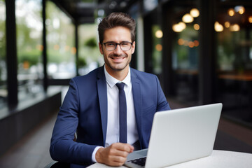 Businessman smiling at the camera while holding a laptop