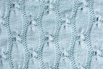 Background with turquoise knitting pattern for sweater with cables. Above overhead shot