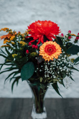 Beautiful bouquet of flowers in a glass vase on a wooden table. Gerberas