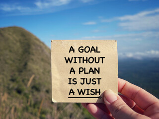 Motivational and inspirational wording. A Goal Without A Plan Is Just A Wish written on a notepad. With blurred styled background.