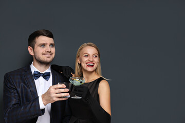 A woman and a man in Halloween costumes on a dark background