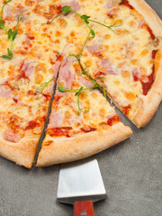 american pizza with ham and mozzarella on a gray background