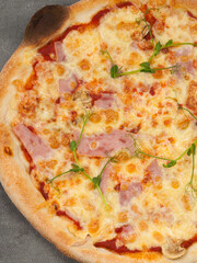 american pizza with ham and mozzarella on a gray background