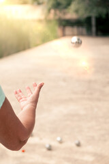 woman throwing a petanque ball.