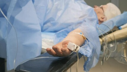 An elderly woman, a grandmother, is on the operating table, having a heart attack.