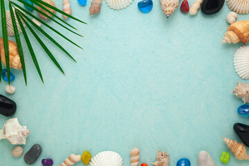 Summer sea background - Sea shells, and colorful stones on a cyan color background. Top view.
