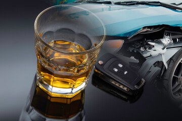 a glass of alcohol, a car key and a crashed car. Do not drink and drive.