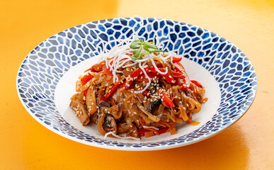 Wok-fried vegetables and mushrooms, Asian style, on a decorative plate.
