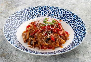 Wok-fried vegetables and mushrooms, Asian style, on a decorative plate.