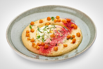 Chickpea hummus on a decorative ceramic plate. White background.